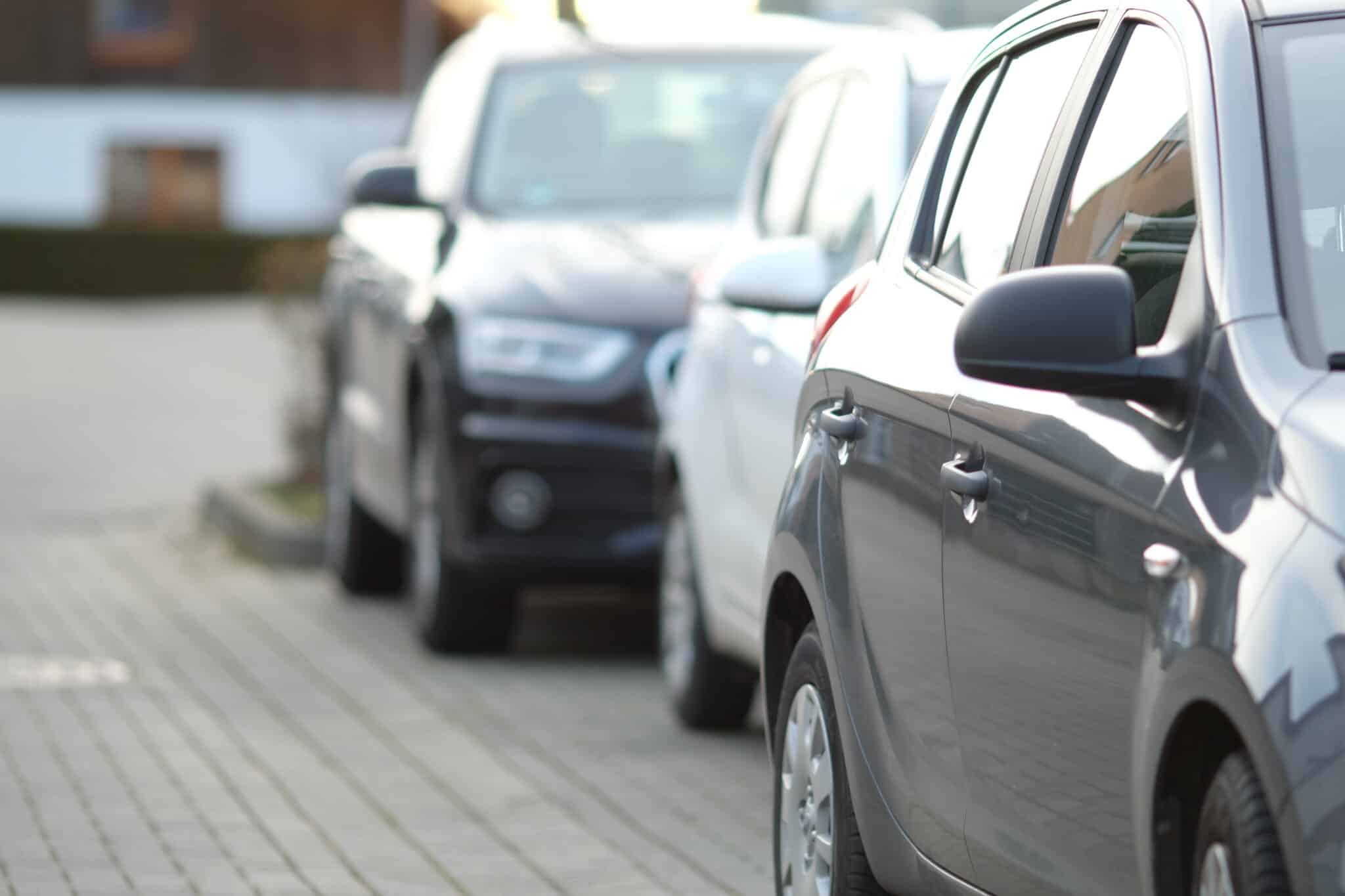 closeup-shot-black-car-parking-lot-with-blurred-background-scaled.jpg